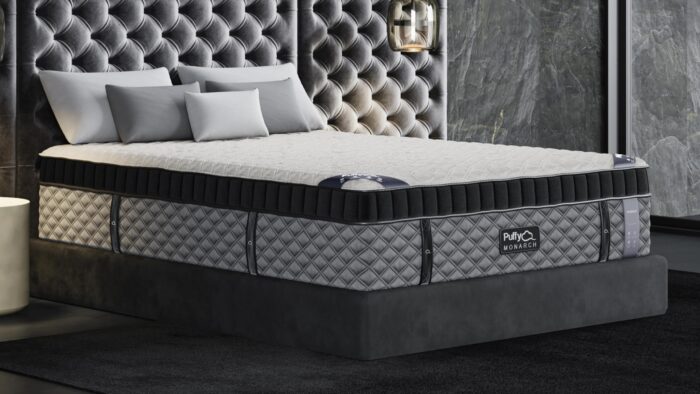 Luxurious modern mattress in sleek bedroom with plush headboard and soft lighting.