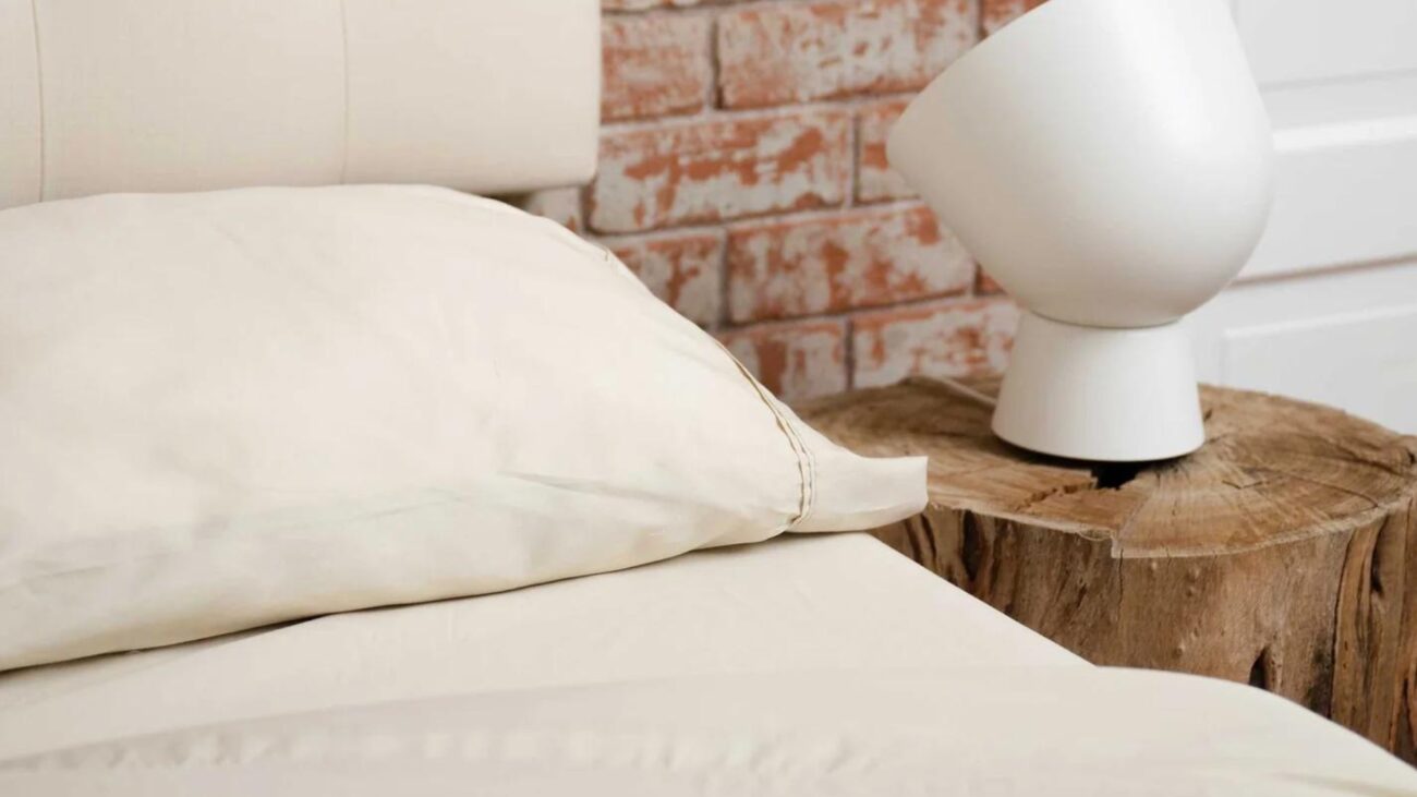 Cozy modern bedroom with rustic charm; stylish headboard, wood bedside table, contemporary lamp.