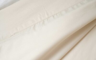 Creamy beige bedding with smooth texture, plush background, and quality craftsmanship.