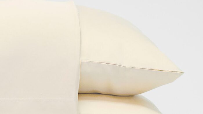 Creamy luxurious pillows exuding comfort and elegance in a tranquil bedroom setting.