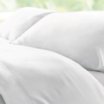 Luxurious white bedding with plush pillows in tranquil, natural light.
