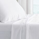 Serene bedroom with ocean view, white linens, inviting relaxation and peace.