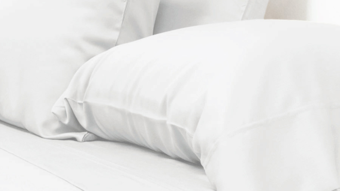 Minimalist white bedding with plush pillows for elegant comfort and relaxation.