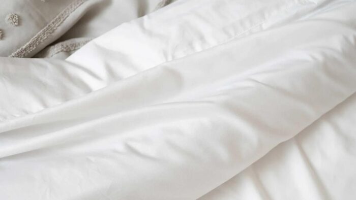 Luxurious white comforter with gray accents, showcasing elegance and comfort in bedroom decor.