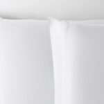 Luxurious white pillowcases with elegant piping for a tranquil and sophisticated bedroom ambiance.