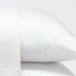 Luxurious white satin pillows showcasing elegance, comfort, and serene bedroom atmosphere.