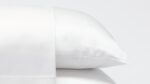 Luxurious white satin pillows showcasing elegance, comfort, and serene bedroom atmosphere.