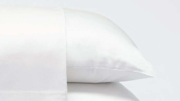 Luxurious white satin pillows showcasing elegance, comfort, and serene bedroom atmosphere.
