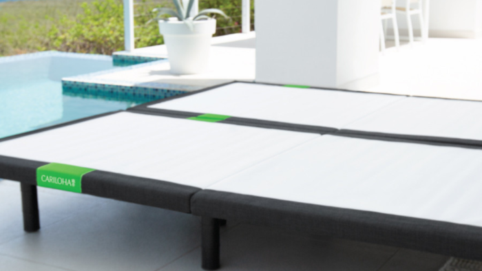 Chic outdoor daybed by pool, blending modern design with serene, natural surroundings.