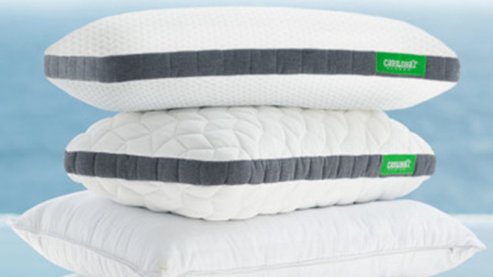 A serene stack of white pillows by the water, offering comfort and modern elegance.