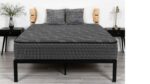 Modern bedroom with gray mattress, black metal frame, wooden nightstands, and decorative elements.