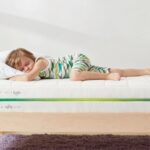 Child sleeping peacefully in cozy bedroom with striped pajamas and minimalist decor.