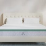 Modern bedroom with HELIX mattress, tufted headboard, and light wood nightstands.