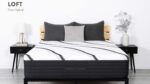 Modern bedroom with LOFT Firm Hybrid mattress, gray pillows, wooden bed, and nightstands.