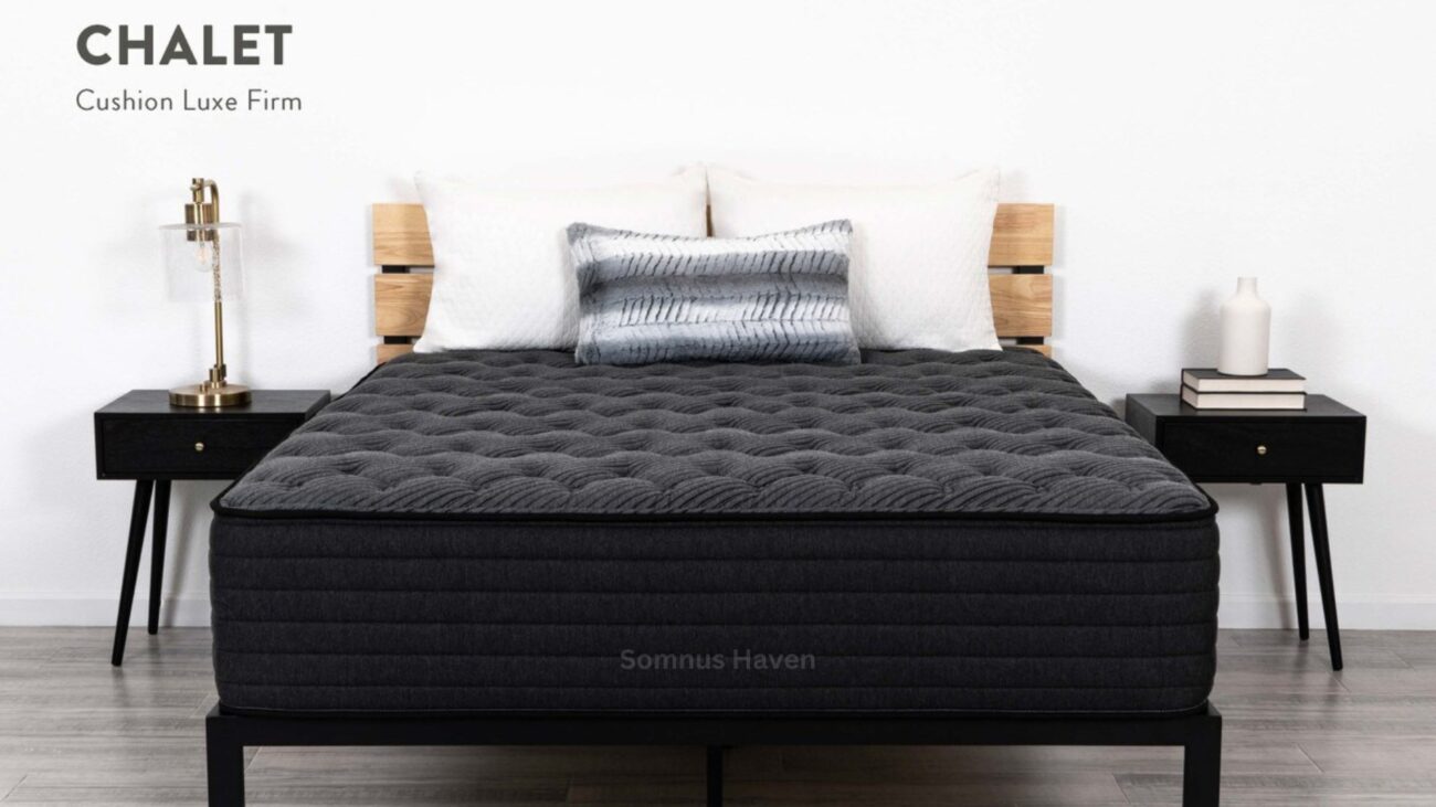 Modern bedroom with CHALET Luxe Firm mattress, geometric pillows, and sleek black furniture.