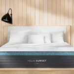 Modern bedroom with Helix Sunset mattress, light wood frame, minimalist decor, and arched windows.