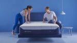 Modern blue bedroom with platform bed, textured mattress, and playful couple. Minimalistic decor.