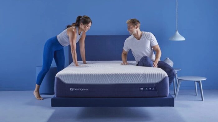Modern blue bedroom with platform bed, textured mattress, and playful couple. Minimalistic decor.