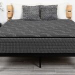 Modern bedroom with geometric mattress, minimalist nightstands, warm lamps, and light wooden floors.