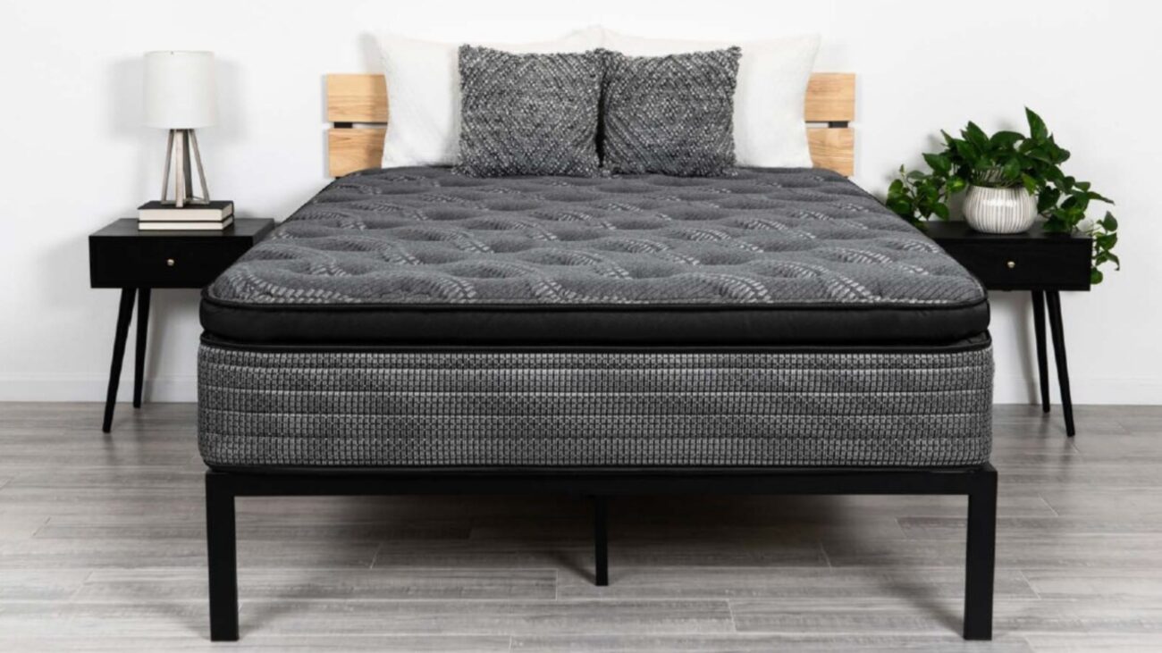Modern bedroom with sleek black metal bed frame, gray quilted mattress, and minimalist decor.