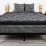 Modern bedroom with sleek black metal bed frame, gray quilted mattress, and minimalist decor.