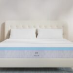 Modern bedroom with plush bed, light gray mattress, wood nightstands, and cozy lighting.