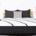 Luxurious modern bedroom with hybrid mattress, wood slat headboard, gray pillows, and elegant decor.