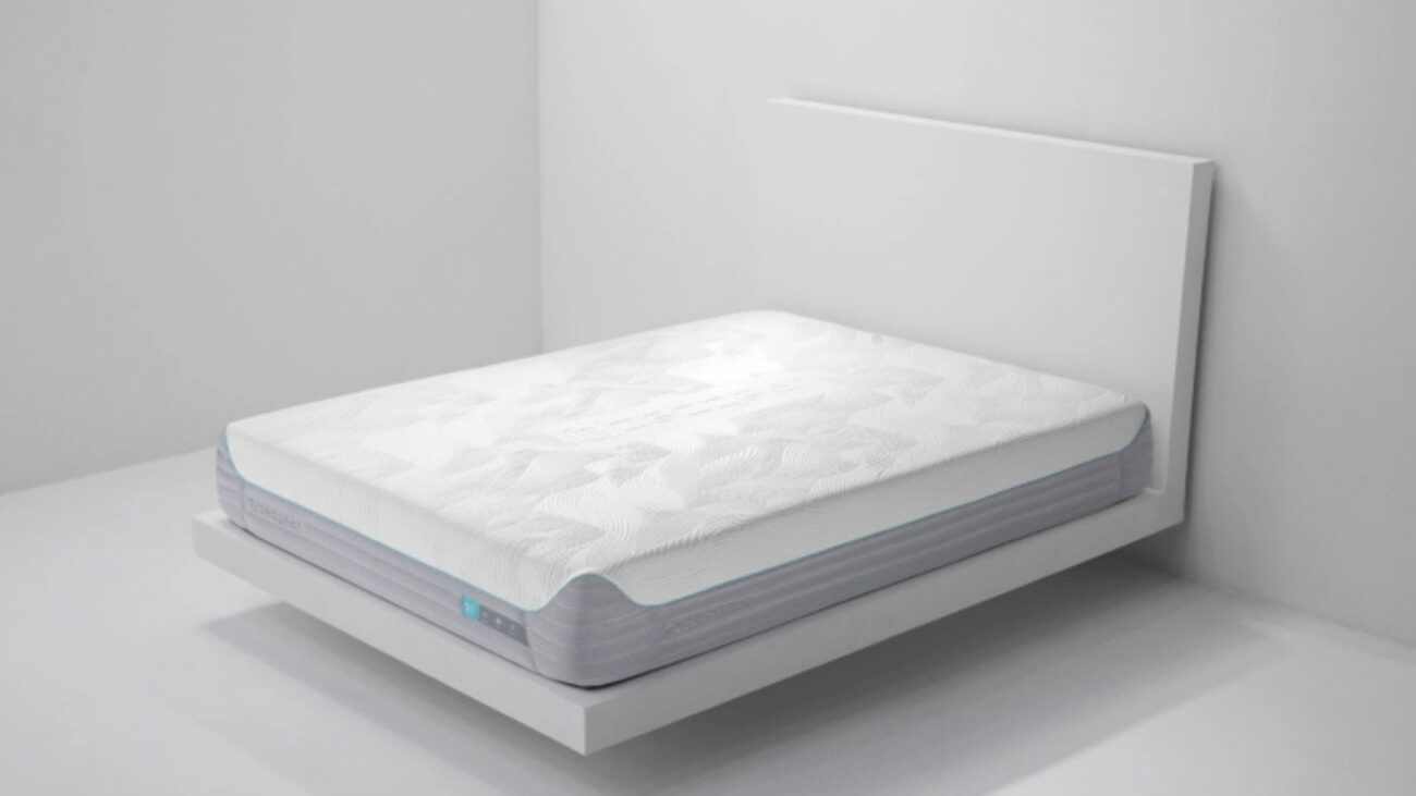 Modern minimalist bedroom with sleek white platform bed and quilted mattress.