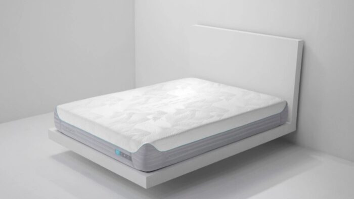 Modern minimalist bedroom with sleek white platform bed and quilted mattress.