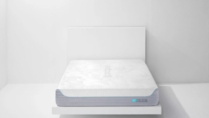 Minimalist bedroom with high-tech adjustable mattress on white platform, promoting relaxation and comfort.