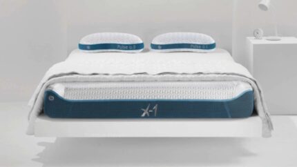 Modern minimalist bedroom with X-1 mattress, blue accents, cozy bedding, and bedside lamp.