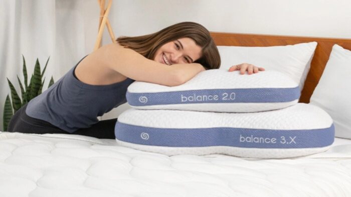 Young woman relaxing with Balance pillows on cozy bed for ultimate comfort.