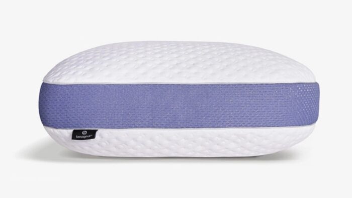 Oval pillow with quilted white top and lavender side band for modern bedroom decor.