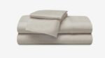 Elegant cream cotton sheet set with fine stitching, perfect for tranquil bedroom decor.