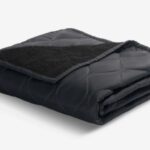 Black quilted blanket with plush texture for warmth and comfort, ideal for stylish home décor.