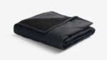 Black quilted blanket with plush texture for warmth and comfort, ideal for stylish home décor.