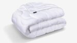Luxurious white quilted comforter with a subtle sheen, perfect for all-season coziness.