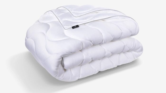 Luxurious white quilted comforter with a subtle sheen, perfect for all-season coziness.