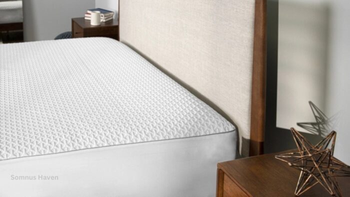 Minimalist bedroom with textured mattress cover, upholstered headboard, and dark wood nightstands.