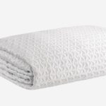 Plush white blanket with interlocking textured pattern, ideal for warmth and home decor.