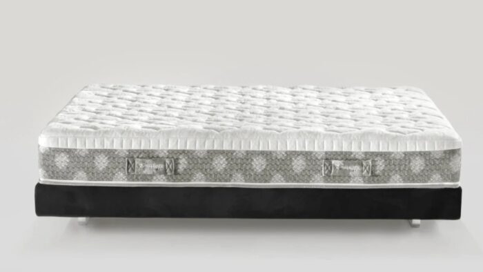 Modern plush mattress with quilted top on sleek black platform base for stylish bedrooms.