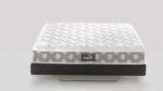 Plush white mattress with quilted surface on gray base, showcasing comfort and modern design.