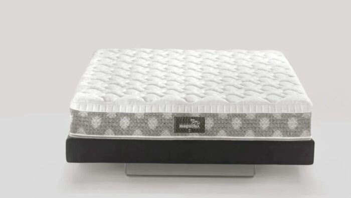 Plush white mattress with quilted surface on gray base, showcasing comfort and modern design.