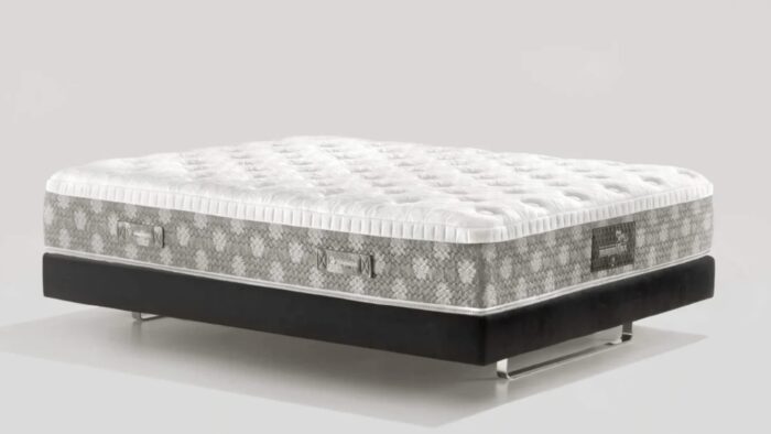 Plush white mattress with geometric sides on sleek black platform bed frame with metallic legs.