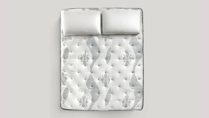 Plush double mattress with pillows in soothing tones, perfect for comfort and elegance.