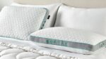 Modern geometric pillows on a white bedspread, designed for comfort and ergonomic support.