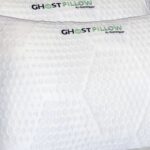 White Ghost Pillow by Ghostbed with cooling texture on a serene, inviting bed.