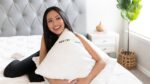 Woman relaxing with GhostPillow in plush bedroom, exuding comfort, elegance, and serenity.