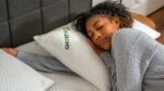 Woman resting on a GHOST pillow, showcasing serene and comfortable sleep environment.