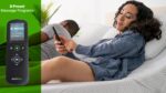 Woman enjoys a massage on a cozy mattress with remote, surrounded by greenery.
